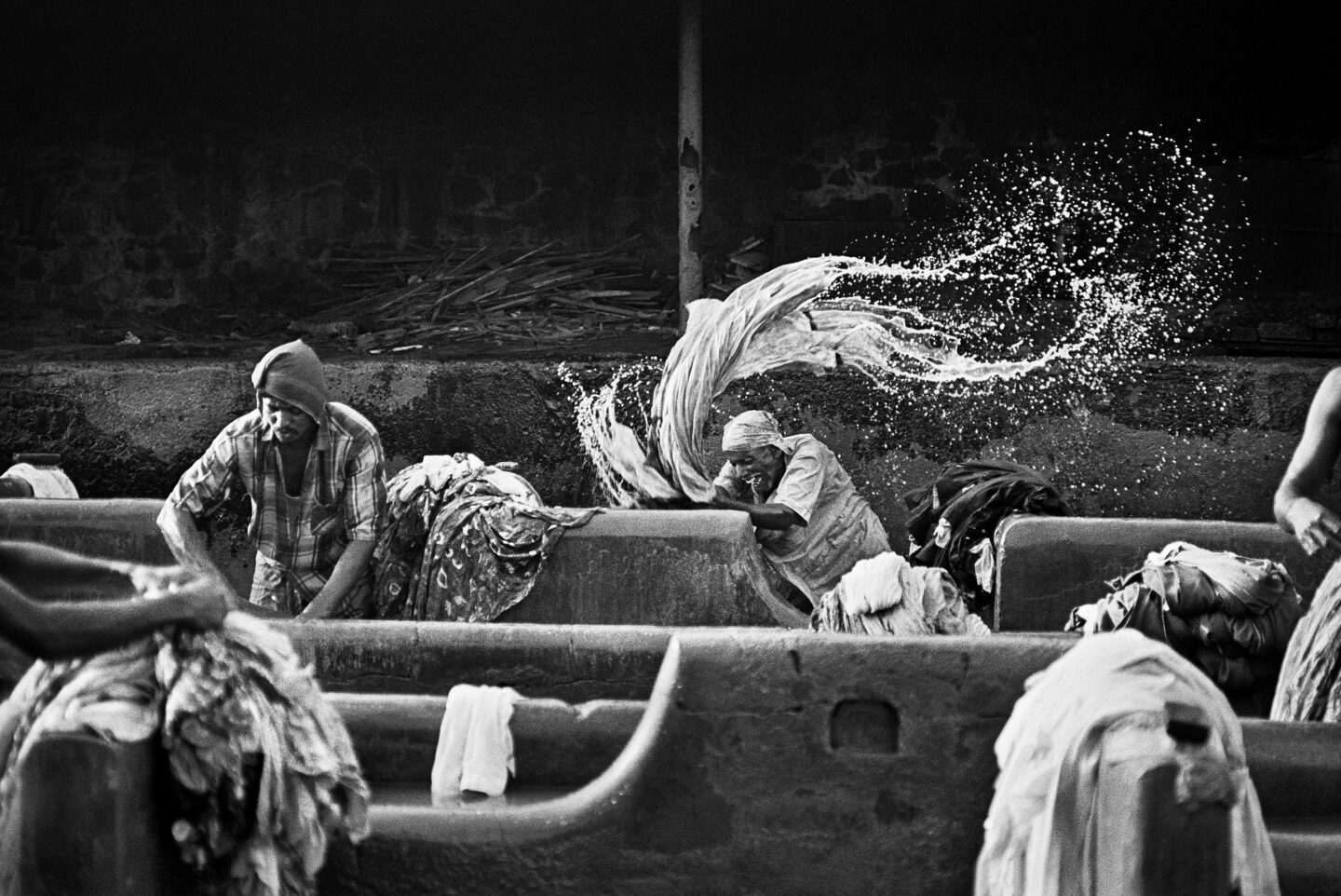 I lavoratori della lavanderia di Mahalaxmi Dhobighat, per lo più emigrati dallo stato di Uttar Pradesh, lavano i vestiti dei privati. Bombay, India, 1995.